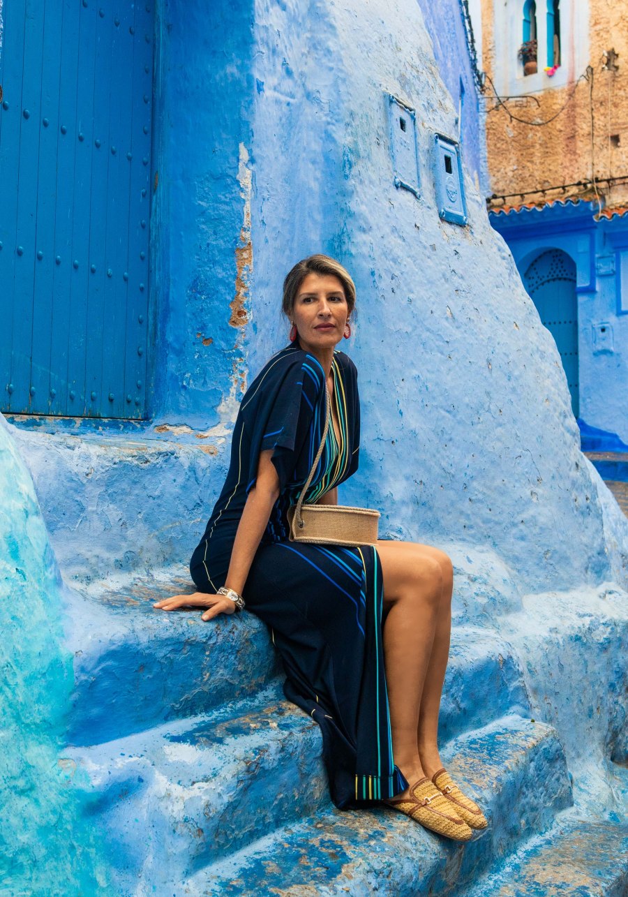 Rachad, native Moroccan host, seated on blue steps in Chefchaouen
